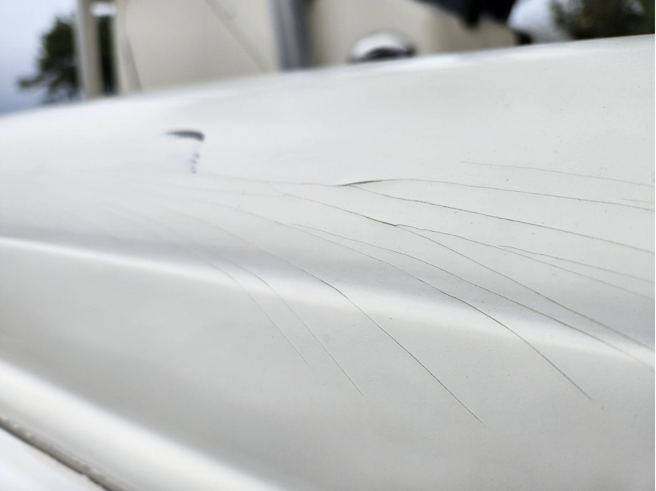Hairline cracks spanning from an impact to the boat’s surface
